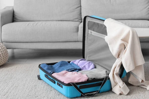Open suitcase with clothes in living room