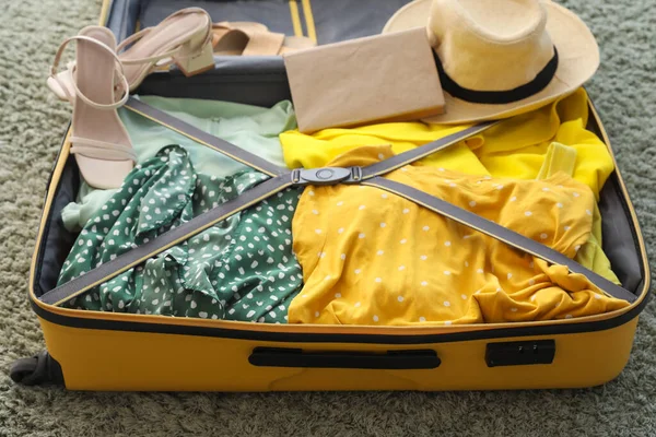 Nyitott Bőrönd Női Ruhákkal Zöld Szőnyegen — Stock Fotó