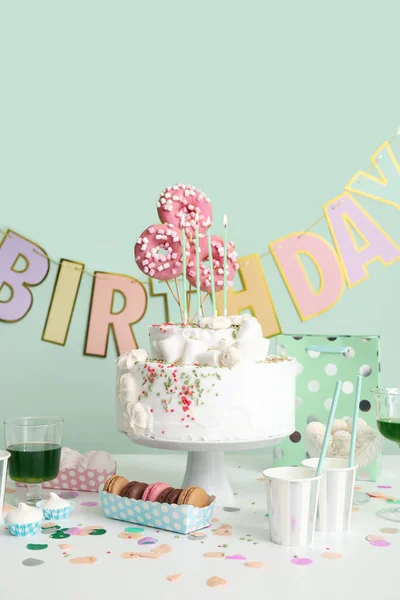 Tort Urodzinowy Różnymi Słodyczami Stole Przy Zielonej Ścianie — Zdjęcie stockowe