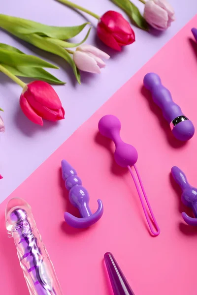 stock image Anal plugs with tulips on color background