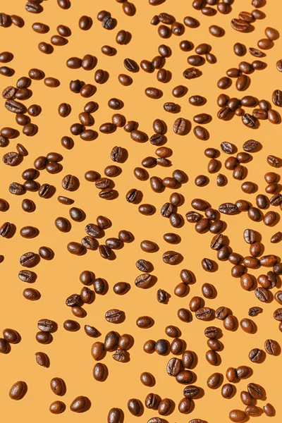 Scattered Coffee Beans Orange Background — Stock Photo, Image