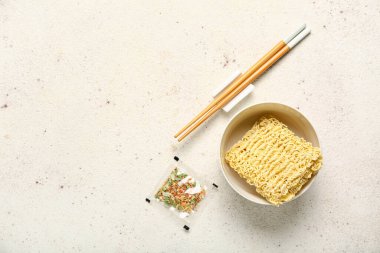 Baharatlı kase içinde çiğ şehriye ve beyaz grunge arka planda çubuklar.