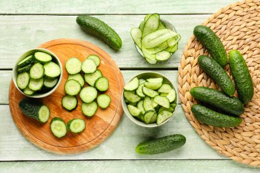 Hafif ahşap arka planda taze kesilmiş salatalıklı kaseler.