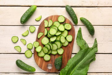 Hafif ahşap arka planda taze kesilmiş salatalıklı tahta.