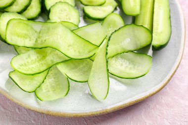Açık arkaplanda taze kesilmiş salatalık tabağı