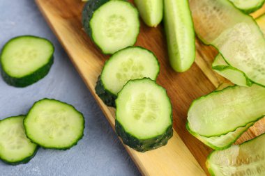 Masada taze salatalık parçaları olan ahşap tahta, yakın plan.