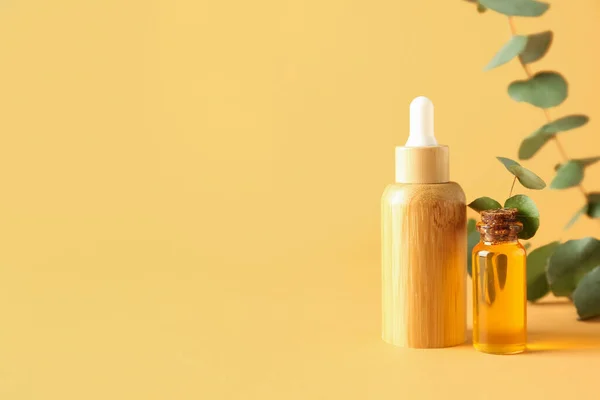 Bottles Cosmetic Oil Eucalyptus Branches Yellow Background — Stock Photo, Image