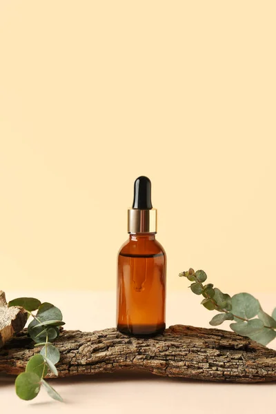 Bottle Cosmetic Oil Eucalyptus Branches Tree Bark Pale Yellow Background — Stock Photo, Image