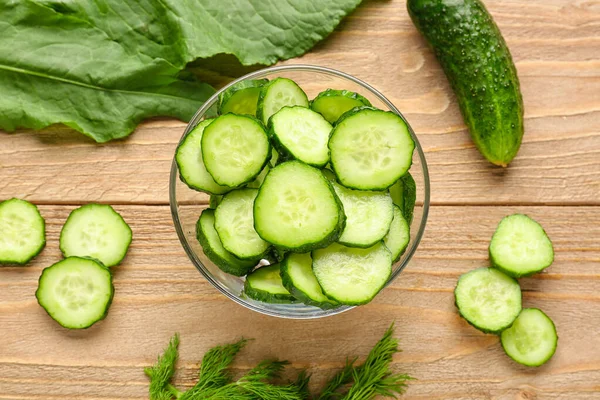 Stock image Bowl with pieces of fresh cucumber on wooden background