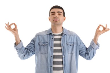 Genç adam beyaz arka plan üzerinde meditasyon yapıyor. Denge kavramı