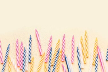 Bej arkaplanda renkli doğum günü mumları