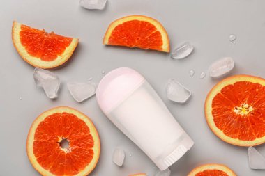 Greyfurt dilimli deodorant ve gri arkaplanda buz