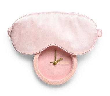 Beyaz arkaplanda uyku maskesi ve alarm saati izole edildi