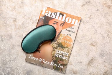 Grunge arka planında uyku maskesi ve dergi