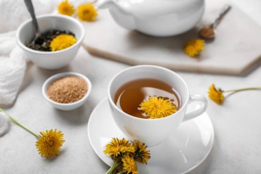 Beyaz arka planda bir fincan sağlıklı karahindiba çayı.