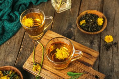 Tahta masada cam bardaklarda sağlıklı karahindiba çayı.