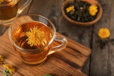 Tahta masada cam bardakta sağlıklı karahindiba çayı.