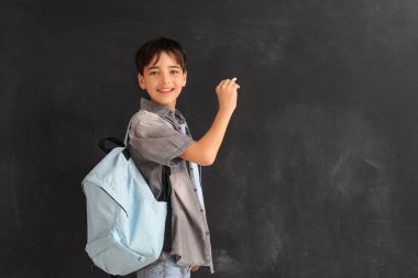 Tahtaya tebeşir parçası çizen küçük çocuk. Çocuk Bayramı kutlaması