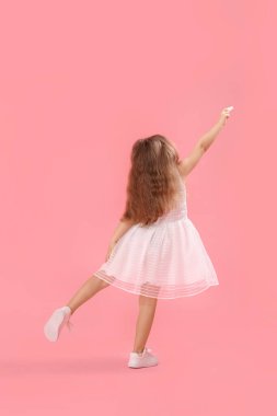 Pembe arka planda tebeşirle çizen küçük bir kız. Çocuk Bayramı kutlaması