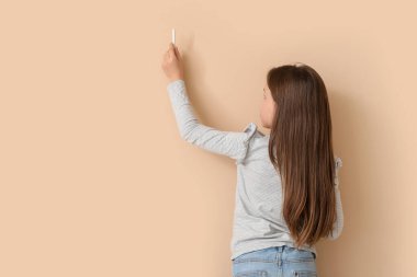 Bej arka planda tebeşirle çizen küçük bir kız. Çocuk Bayramı kutlaması