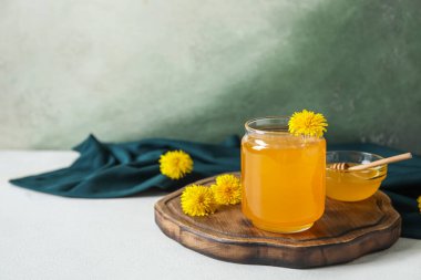 Kavanoz ve karahindiba ile beyaz masada bal