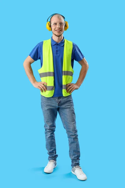 Male Worker Vest Protective Headphones Blue Background — Stock Photo, Image