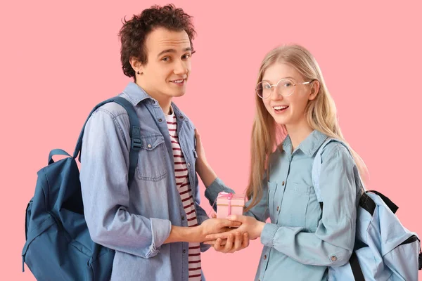 Teenager Grüßt Seine Freundin Mit Geschenk Auf Rosa Hintergrund — Stockfoto