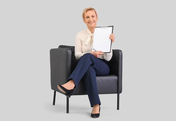 Mature Businesswoman Clipboard Sitting Armchair Grey Background — Stock Photo, Image