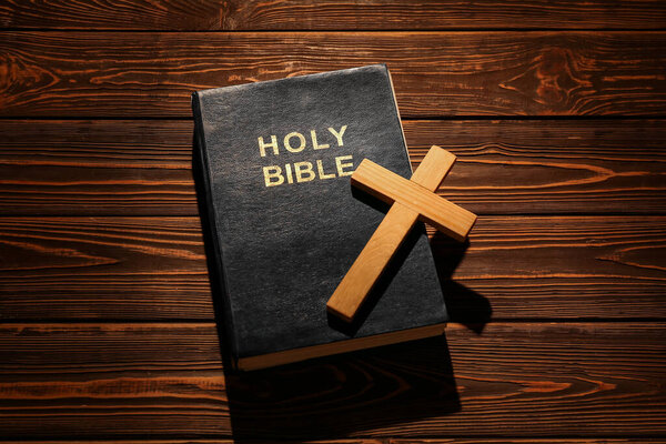 Holy Bible with cross on wooden background