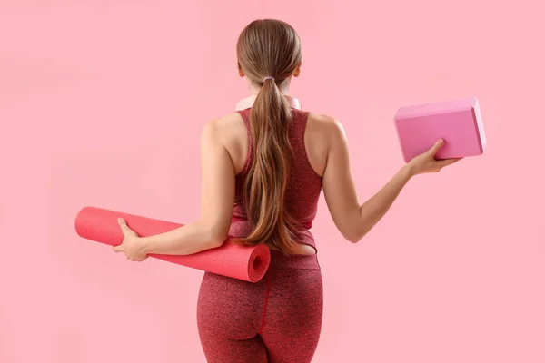 一个身材苗条的年轻女子 带着垫子和粉色背景的瑜伽块 — 图库照片