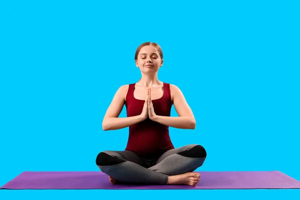 Zwangere Jonge Vrouw Doet Yoga Blauwe Achtergrond — Stockfoto