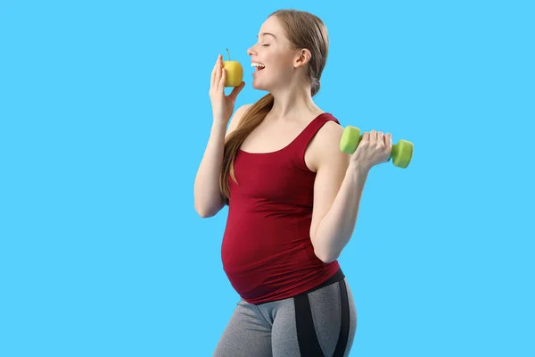 Sportig Gravid Kvinna Med Äpple Och Hantel Blå Bakgrund — Stockfoto