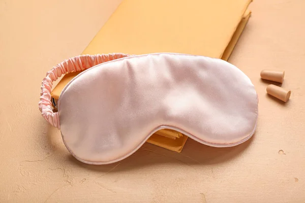 耳栓付きノートとベージュの背景に睡眠マスク — ストック写真