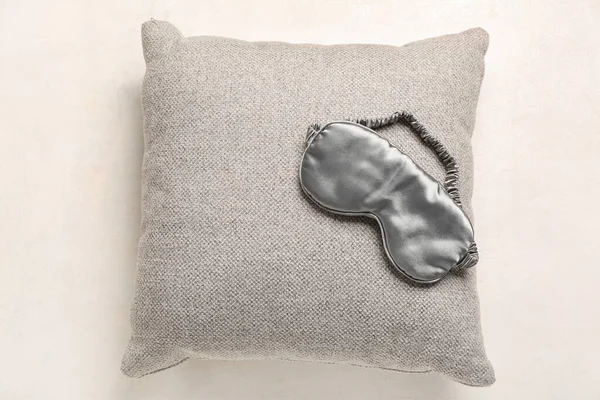 Sleeping mask and pillow on light background