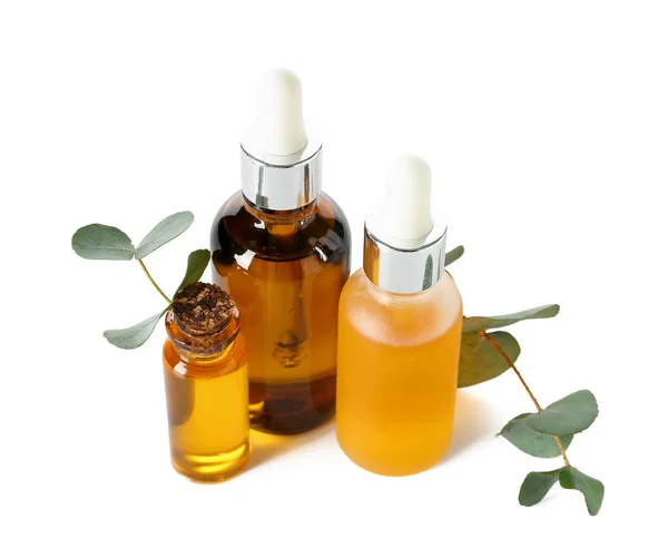 Flaskor Med Kosmetisk Olja Och Eukalyptus Gren Vit Bakgrund — Stockfoto