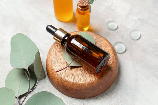 Cosmetic Oil Bottles Wooden Stand Eucalyptus Branch Textured Background — Stock Photo, Image