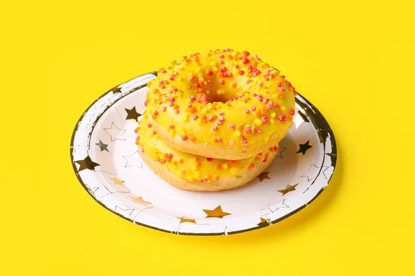Paper disposable plate with donuts on yellow background