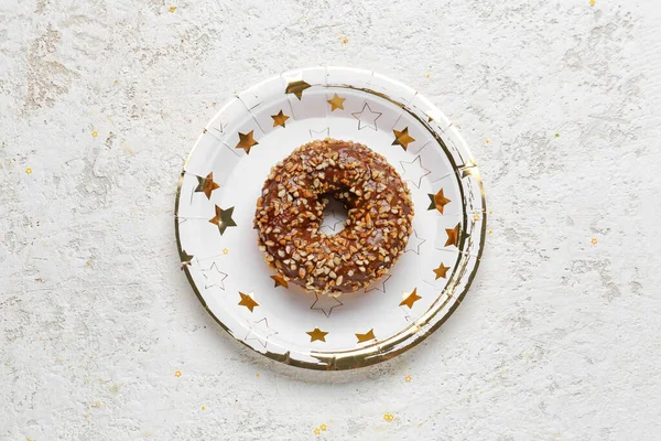 Paper disposable plate with doughnut on grunge background