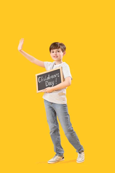 Kleiner Junge Mit Kreidetafel Mit Dem Text Kindertag Auf Gelbem — Stockfoto