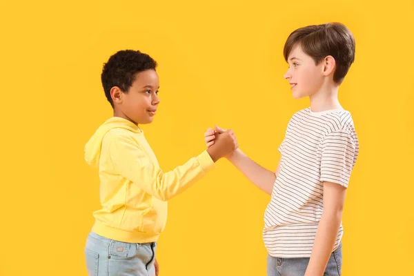 Små Pojkar Som Håller Hand Gul Bakgrund Barnens Dag Firande — Stockfoto