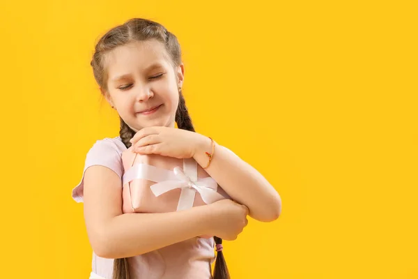 Mała Dziewczynka Prezentem Żółtym Tle Obchody Dnia Dziecka — Zdjęcie stockowe