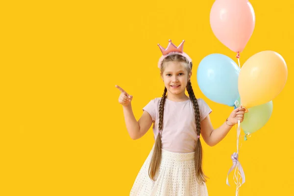 Маленька Дівчинка Короні Кульками Вказують Щось Жовтому Тлі Дитячий День — стокове фото