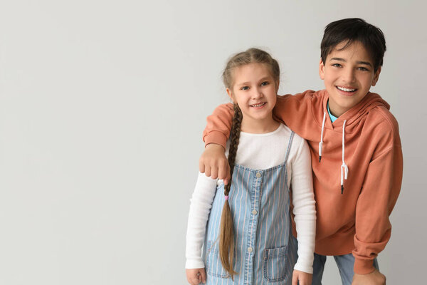Маленькие дети обнимаются на светлом фоне