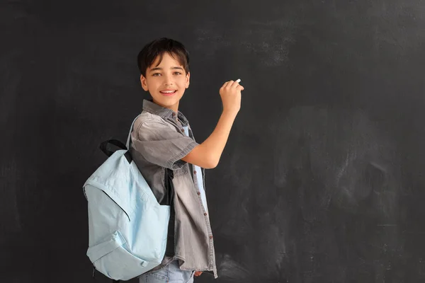 Little boy with chalk piece drawing on blackboard. Children\'s Day celebration