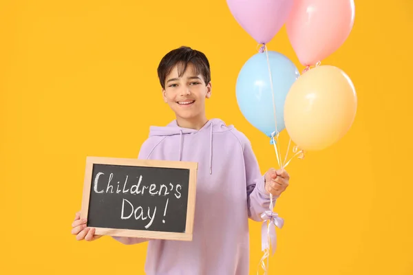 Little Boy Holding Chalkboard Text Children Day Balloons Yellow Background — Stock Photo, Image