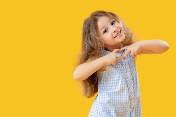 小女孩双手插在黄色的背景上 心情舒畅 儿童节庆祝活动 — 图库照片