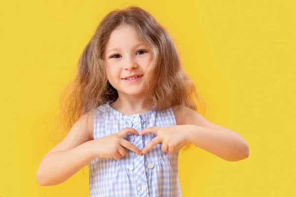 Κοριτσάκι Που Κάνει Καρδιά Χέρια Στο Κίτρινο Φόντο Γιορτή Της — Φωτογραφία Αρχείου