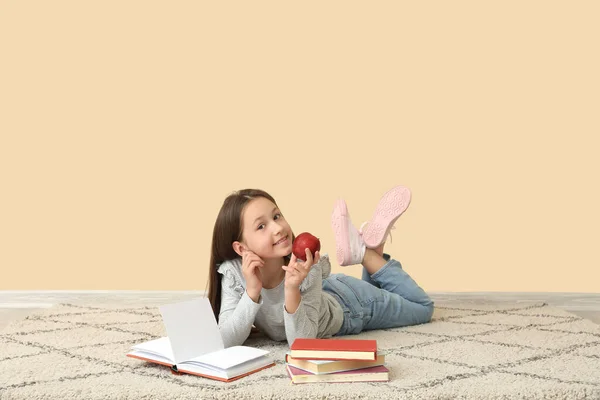 Κοριτσάκι Βιβλίο Ανάγνωσης Μήλων Κοντά Μπεζ Τοίχο Γιορτή Της Ημέρας — Φωτογραφία Αρχείου