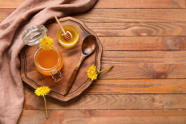 stock image Jar and bowl with dandelion honey on wooden background