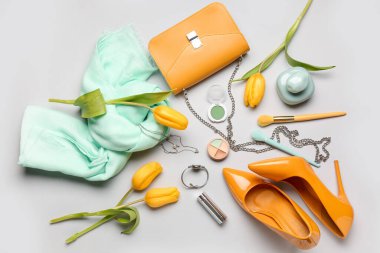 Hafif arkaplanda şık kadın aksesuarları, kozmetik ürünleri ve lale çiçekleri olan kompozisyon